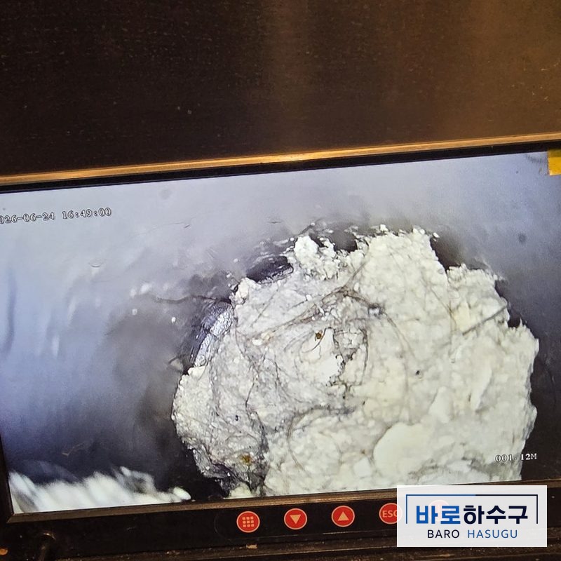 욕실 배관 내시경 화면, 하얗게 굳은 석회 덩어리가 관을 거의 막고 있는 작업 전 상태